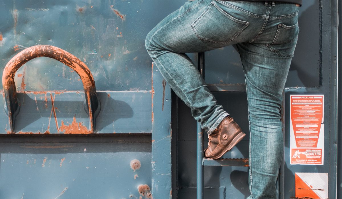 A worker climbing a container ladder: the occupational risk that statutory cover protects