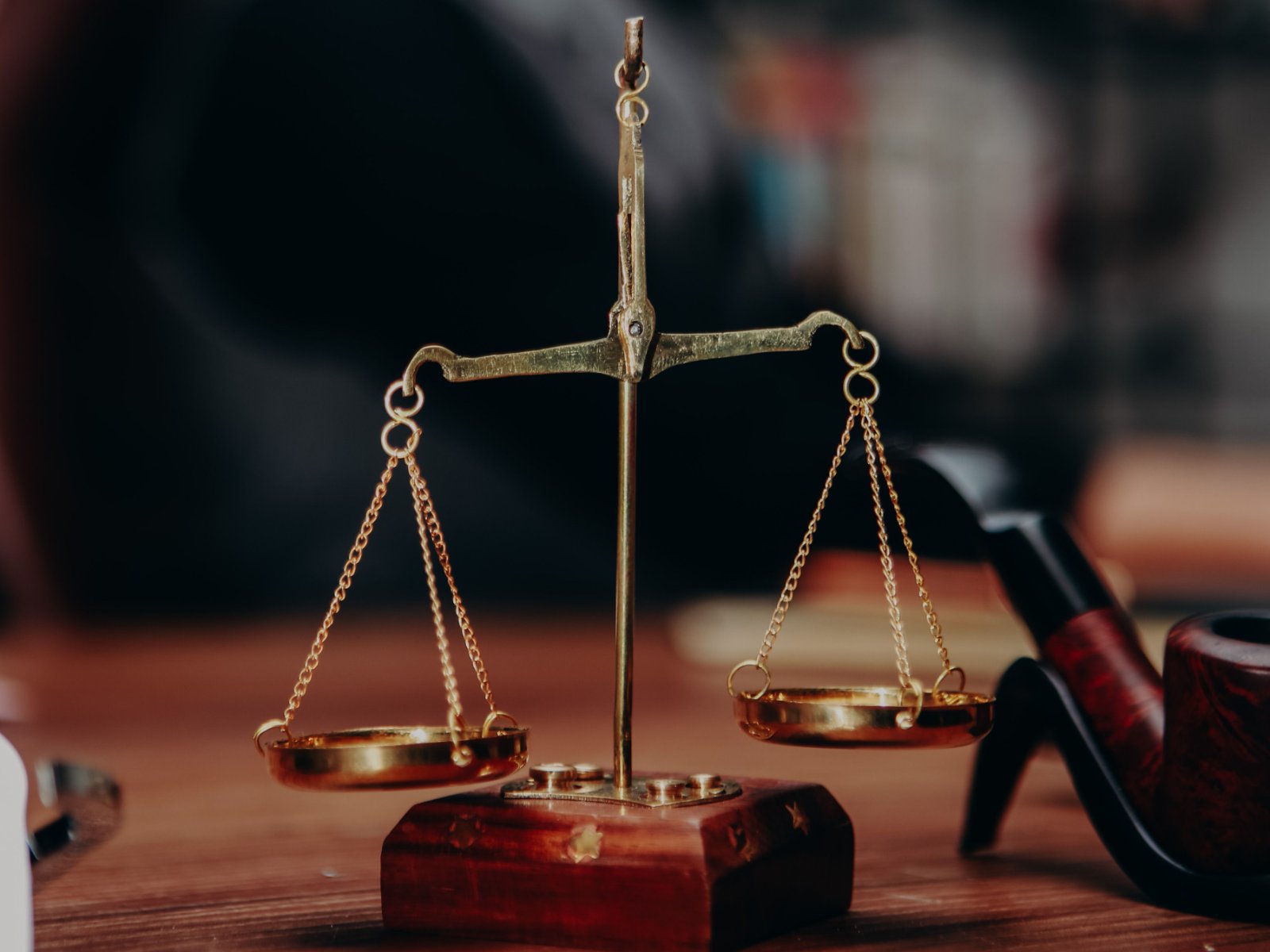 Brass scales of justice on a lawyer's desk: legal expenses insurance funds the costs of enforcing your rights
